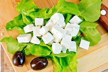 Image showing Feta with green lettuce and black olives on board