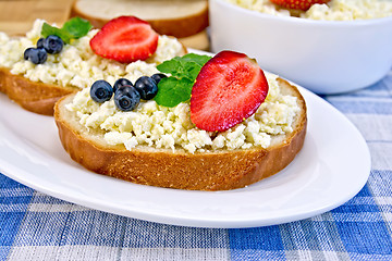 Image showing Bread with curd and berries on blue checkered cloth