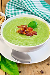 Image showing Soup puree with bacon and spoon on board