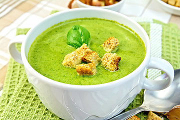 Image showing Soup puree with spinach and spoon on a napkin