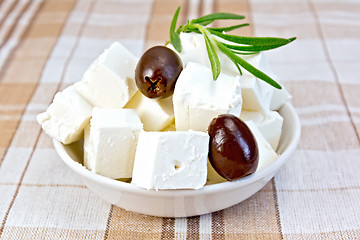 Image showing Feta with olives in cup on brown cloth