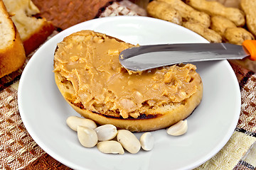 Image showing Sandwich with peanut butter and knife on napkin