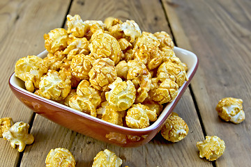 Image showing Popcorn caramel on board in clay bowl