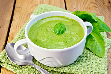Image showing Soup puree with spinach leaves on board
