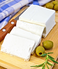 Image showing Feta with olives on board with blue cloth