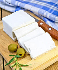 Image showing Feta with olives and rosemary on board with knife