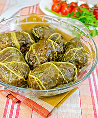 Image showing Rhubarb leaves stuffed in glass dish on fabric