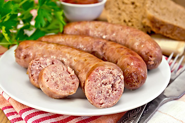 Image showing Sausages pork fried in plate on board with parsley