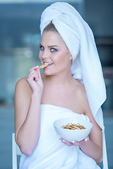 Image showing Woman in Bath Towel Eating Snacks from Bowl