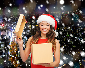 Image showing smiling woman in santa helper hat with gift box