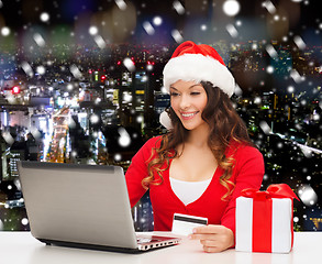 Image showing smiling woman with credit card and laptop