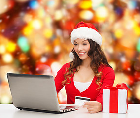 Image showing smiling woman with credit card and laptop