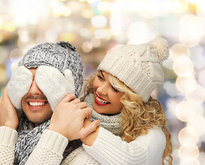 Image showing smiling couple in sweaters and santa helper hats