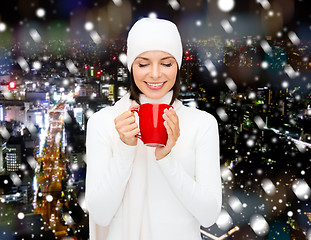 Image showing smiling young woman in winter clothes with cup