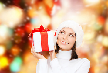 Image showing smiling woman in santa helper hat with gift box