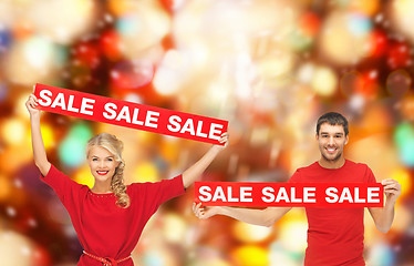Image showing smiling man and woman with red sale signs