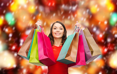 Image showing woman in red dress with colorful shopping bags