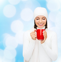 Image showing smiling young woman in winter clothes with cup