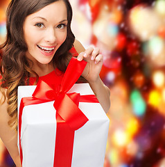 Image showing smiling woman in red dress with gift box