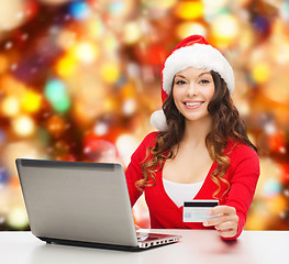 Image showing smiling woman with credit card and laptop