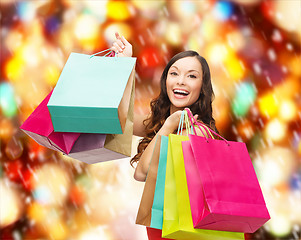 Image showing woman in red dress with colorful shopping bags