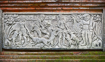 Image showing Images of people and dogs carved on a stone plate. Indonesia, Ba