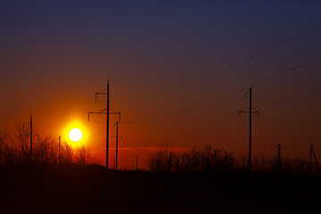 Image showing Poles of power lines at sunset - industrial landscape