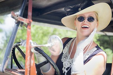 Image showing Attractive Woman in Twenties Outfit Driving an Antique Automobil