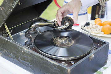 Image showing Man Starting Antique Phonograph Record Player