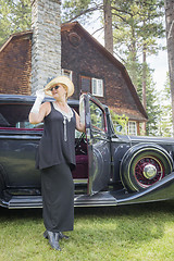 Image showing Attractive Woman in Twenties Outfit Near Antique Automobile