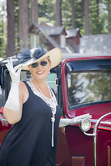 Image showing Attractive Woman in Twenties Outfit Near Antique Automobile