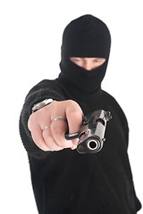 Image showing masked man aims from gun in you. Focus on gun