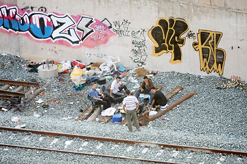 Image showing Group of men hanging out next to railway