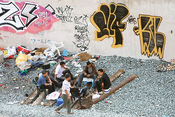 Image showing Small group of men hanging out next to railway