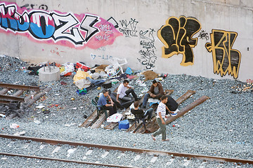 Image showing Group of local men hanging out next to railway