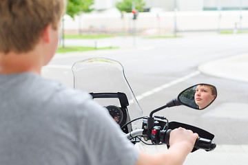 Image showing Teenager riding a motorcycle at street junction