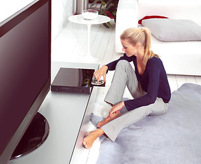 Image showing woman using dvd player in flat