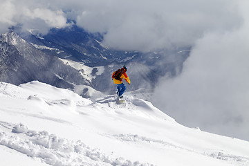 Image showing Snowboarder on off-piste slope an mountains in fog