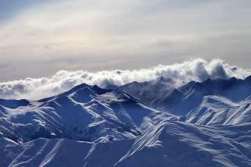 Image showing Snowy mountains in mist at winter evening