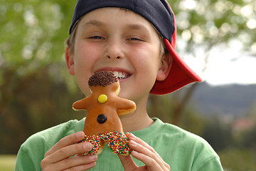 Image showing Grinning  boy with a doughnut