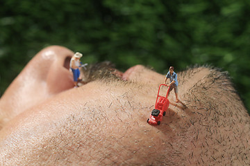 Image showing Little People Mowing Hair off a Mans Face