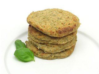 Image showing potato dough cakes with basil lying upon another