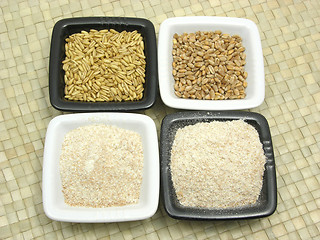 Image showing Bowls of chinaware with cereal and wholemeal on rattan mat