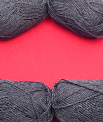Image showing Gray new wool as frame on red felt as background