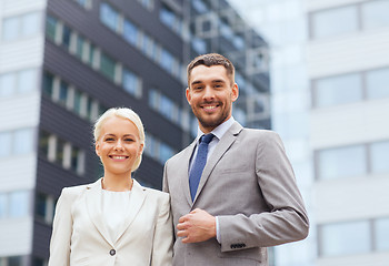 Image showing smiling businessmen standing over office building