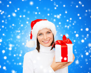 Image showing smiling woman in santa helper hat with gift box