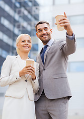 Image showing smiling businessmen with paper cups outdoors