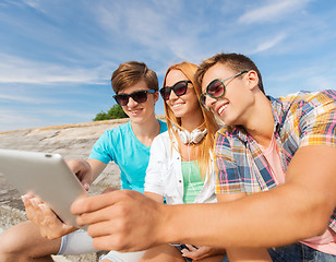 Image showing group of smiling friends with tablet pc outdoors