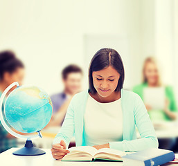 Image showing teacher with globe and book at school