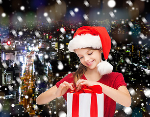 Image showing smiling girl in santa helper hat with gift box